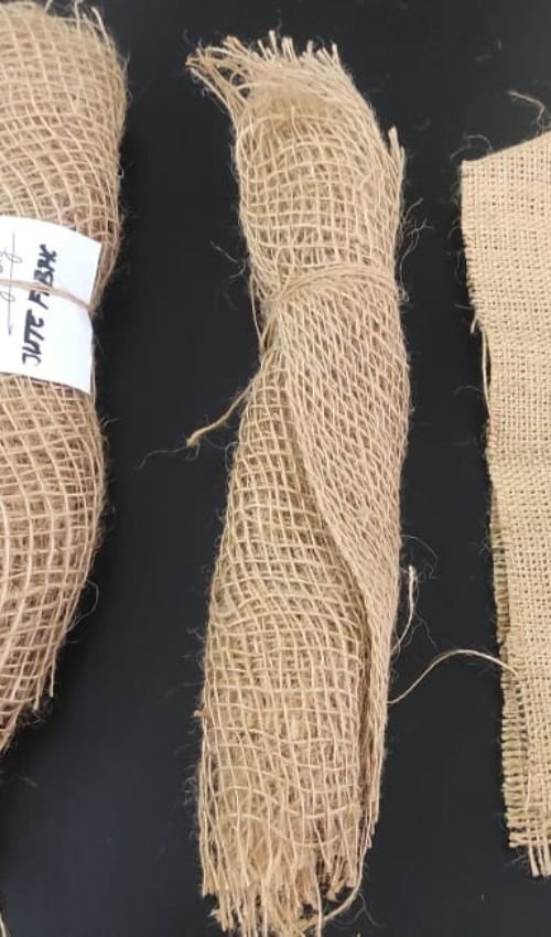 Rolled natural burlap jute fabric samples displayed vertically showing texture and weave